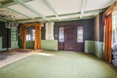 Front door with leaded glass sidelights opens onto