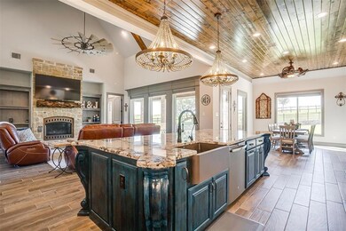 Oversized island with exquisite chandelier accenting all the beauty and charm this kitchen has to offer.