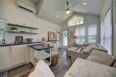 Living room featuring ceiling fan, vaulted ceiling