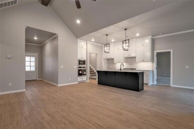 Kitchen featuring light hardwood / wood-style flooring, an island with sink, and white cabinetry