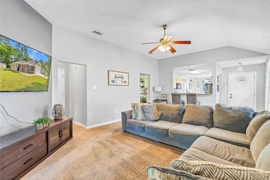 Carpeted living room featuring lofted ceiling, bas