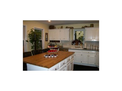 Spacious kitchen with butcher block island.