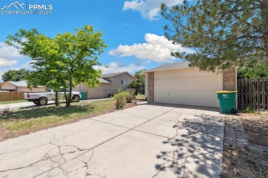 View of front of home featuring brick siding, concrete driveway, and a garage