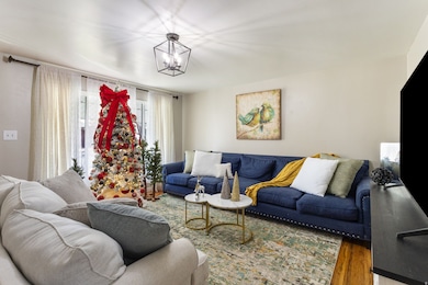 Living room featuring wood finished floors and a chandelier
