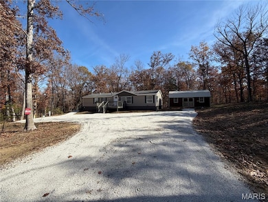 View of front of house with gravel driveway