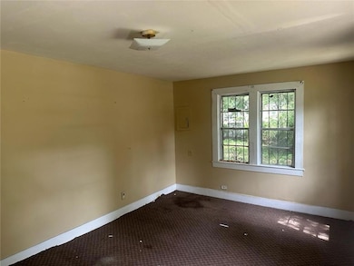 Empty room with baseboards, dark carpet, and electric panel