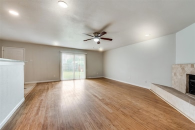 Unfurnished living room with a ceiling fan, light wood finished floors, a tiled fireplace, and recessed lighting