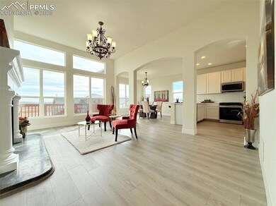 Dining space with arched walkways, a chandelier, light wood-style floors, and recessed lighting