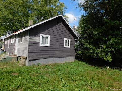 View of property exterior featuring a chimney and a yard
