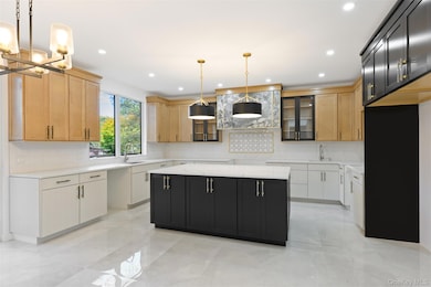 Kitchen featuring a center island, glass insert cabinets, light stone countertops, pendant lighting, and tasteful backsplash