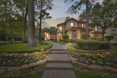 Front of home with lush landscaping and lighting