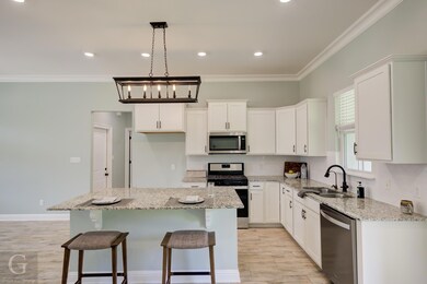 Kitchen with light stone counters, sink, a kitchen