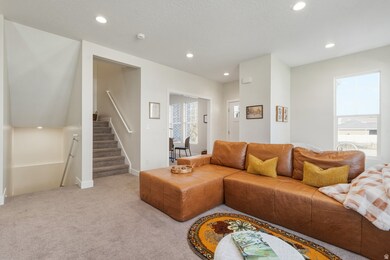 Living room with recessed lighting, light carpet, healthy amount of natural light, stairway, and a textured ceiling