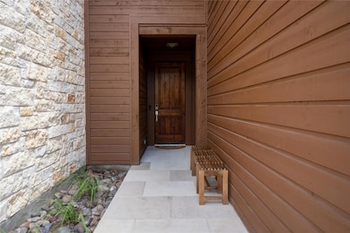 Doorway to property featuring stone siding
