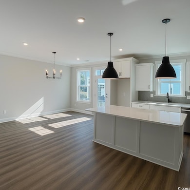 Kitchen featuring white cabinets, decorative light fixtures, recessed lighting, dark wood-style flooring, and backsplash
