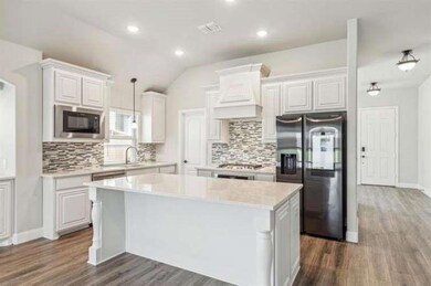 Kitchen with built in microwave, white cabinetry, 