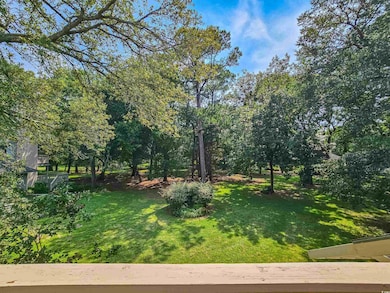 View of grassy yard with view of wooded area