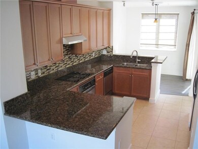 Updated kitchen with light brown cabinetry, new tile back splash, granite counters and SS appliances.