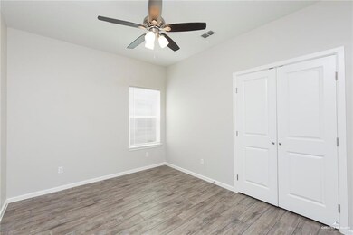Unfurnished bedroom featuring wood finished floors, a closet, and a ceiling fan