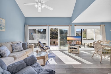 Living room with ceiling fan, lofted ceiling, and 