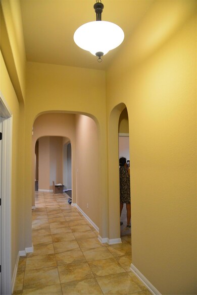Hall featuring arched walkways and baseboards