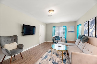 Living room with wood finished floors, visible ven