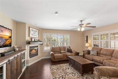 Separate family room with corner fireplace, ceiling fan, hard wood flooring and more plantation shutters! View of pool as well.