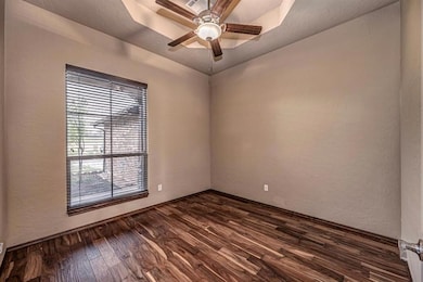 Empty room featuring a textured wall, a raised cei