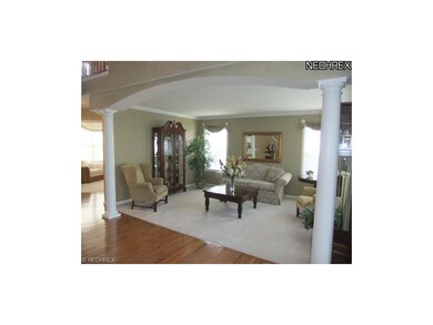 The stunning living room features pillared entranc
