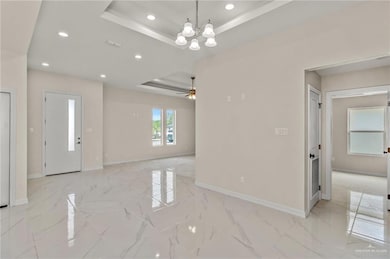 Living room with a tray ceiling and ceiling fan