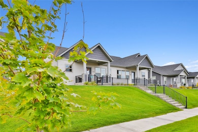 View of front facade with a front lawn, a porch, a shingled roof, and stairway