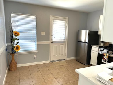 Kitchen featuring white cabinetry, appliances with stainless steel finishes, and light tile patterned floors