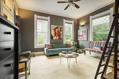 Living area with ornamental molding, light wood-style flooring, plenty of natural light, and a ceiling fan