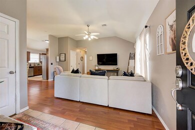Living room featuring vaulted ceiling, ceiling fan
