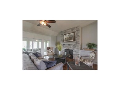 Cozy, floor to ceiling stacked stone fireplace has