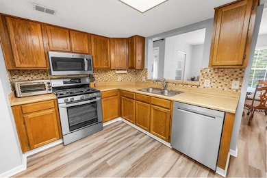 Kitchen featuring stainless steel appliances, a sink, and light wood finished floors
