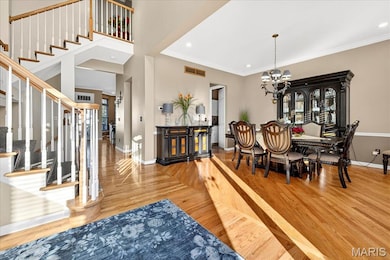 Dining space featuring stairway, recessed lighting, light wood-style floors, crown molding, and a chandelier