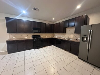 Spacious kitchen featuring dark cabinets, granite