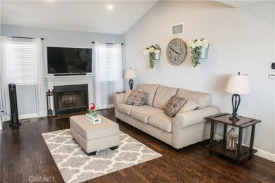 Living Room with high ceilings, recessed lighting, beautiful Oak hardwood floors, plantation shutters and fireplace with mantle.