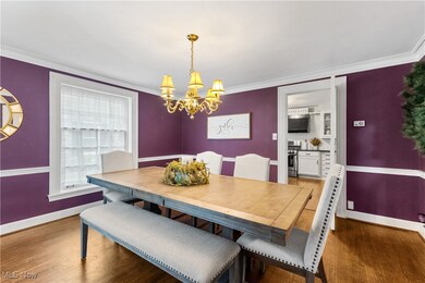 Dining area featuring pristine crown molding and hardwood / wood-style floors