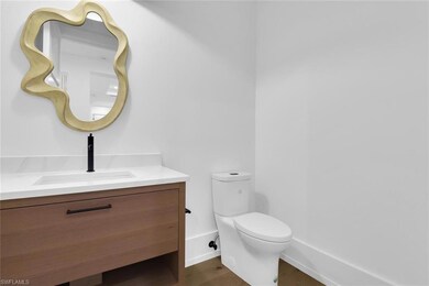 Bathroom with toilet, vanity, wood finished floors