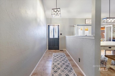 Doorway to outside with a textured wall and a chandelier