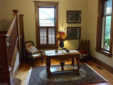 Foyer with beautiful leaded glass windows & sidelights, lovely wood flooring.