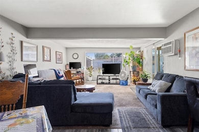 Living room featuring an AC wall unit and carpet