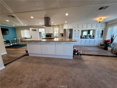 #69 San Rafael - Great Room living room area with carpet. Kitchen has small raised step up laminate flooring. PLEASE BE CAREFUL WHEN WALKING AROUND. Thank you