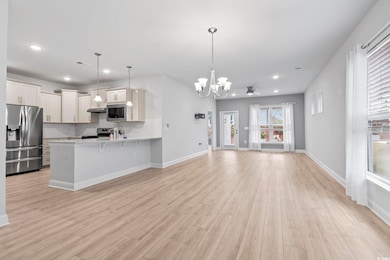 Open floor plan, decorative light fixtures, a chandelier, and recessed lighting.