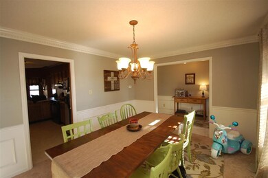 The dining room has wide windows that illuminate t