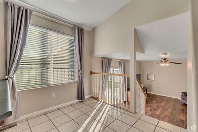 Empty room with light tile patterned floors and a ceiling fan