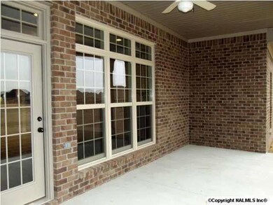 Covered back porch with lots of windows and ceiling fan.