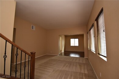 Spare room with visible vents, baseboards, dark colored carpet, and stairs